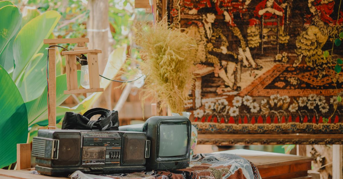 Décor rétro avec télévision ancienne, lecteur cassette et fond tapisserie pour ambiance nostalgique