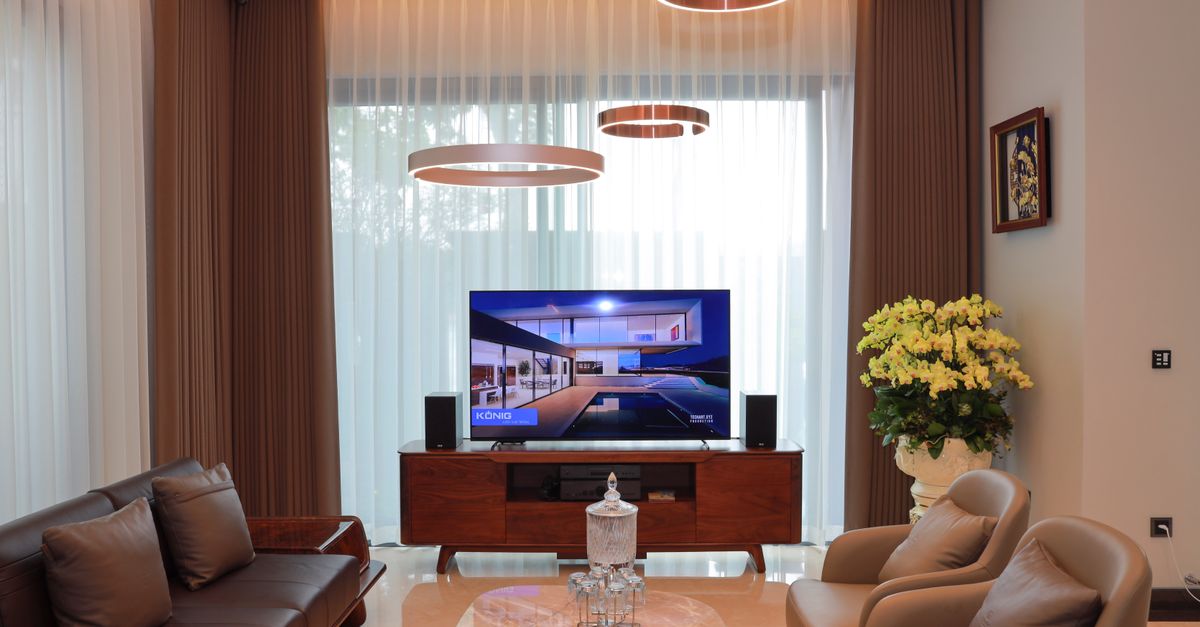 Salon moderne avec télévision allumée, mobilier élégant et décoration contemporaine