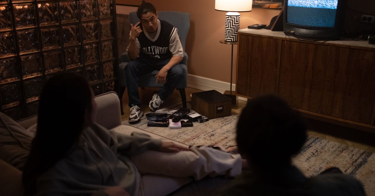 Trois amis assis dans un salon chaleureux regardent un film ensemble à la télévision