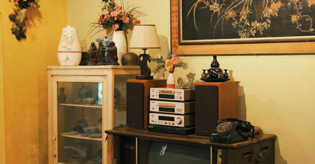 Salon vintage chaleureux avec appareils électroniques anciens et décoration artistique aux tons chauds.