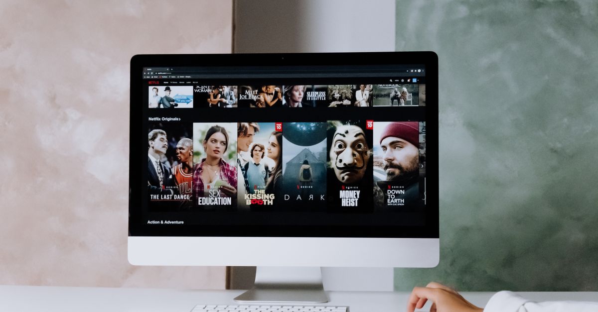 Bureau moderne avec ordinateur affichant une série en streaming sur un écran large