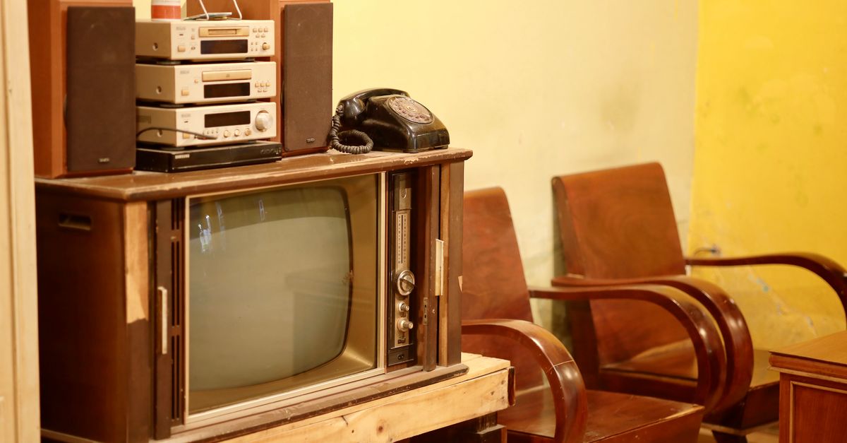 Salon rétro avec télévision ancienne, platine vinyle et décoration vintage sur une commode