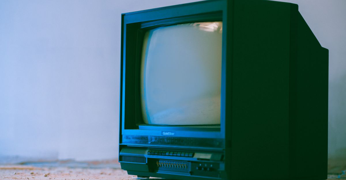 Ancien téléviseur à boîtier en plastique posé contre un mur blanc