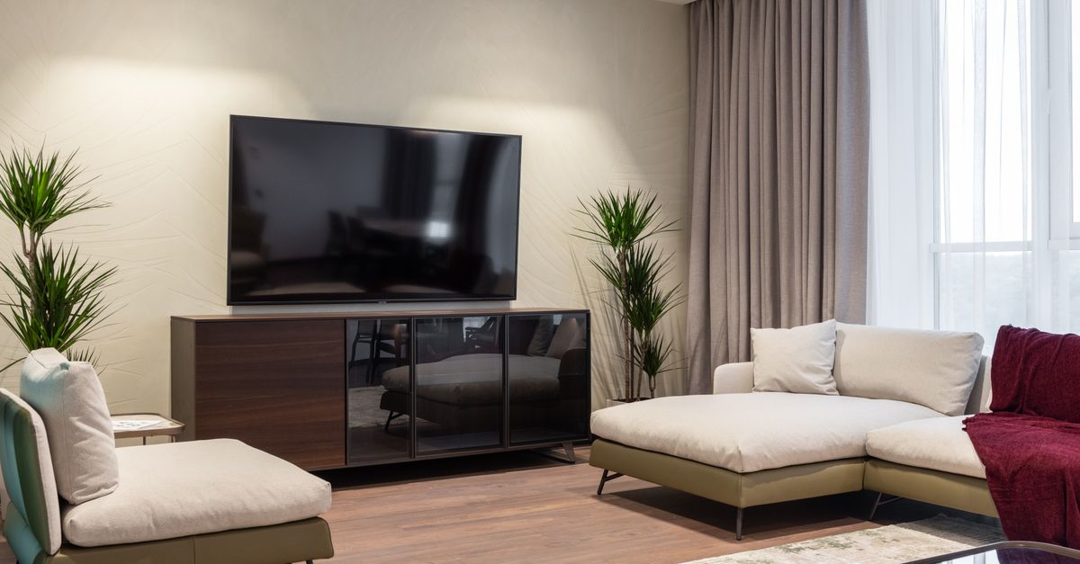 Salon moderne lumineux avec canapé confortable, fauteuil et table basse en verre