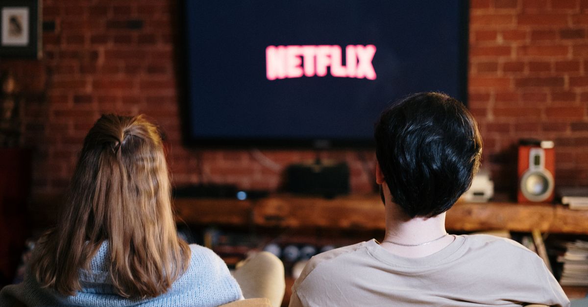 Un couple détendu profite d’une soirée à regarder Netflix dans leur salon confortable
