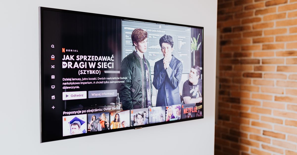 Téléviseur connecté affichant des contenus de streaming dans un salon moderne avec mur en briques apparentes