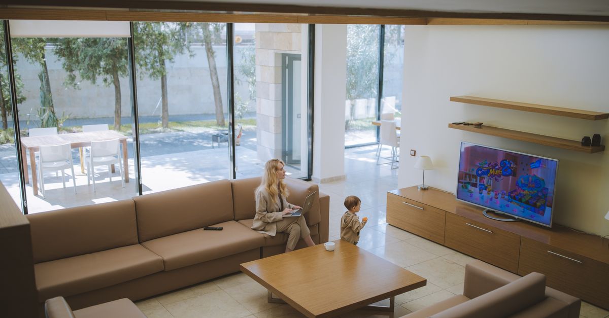 Salon lumineux et moderne où une femme et un enfant regardent la télévision ensemble