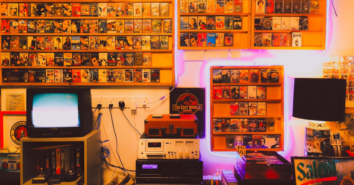 Salon rétro avec équipements audio anciens, cassettes et télévision d’époque sur un meuble